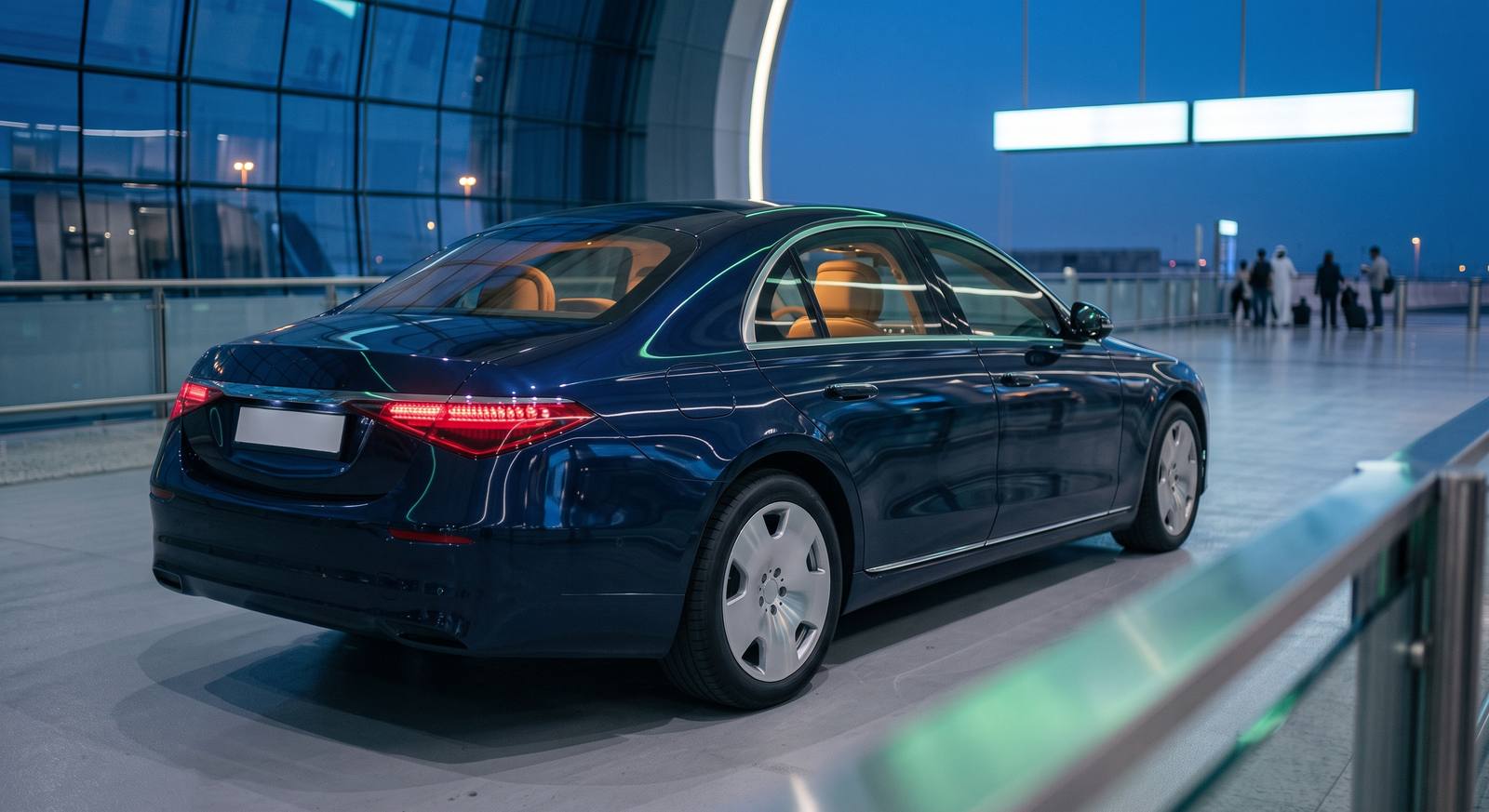 An executive sedan waiting at a UAE airport terminal at dusk