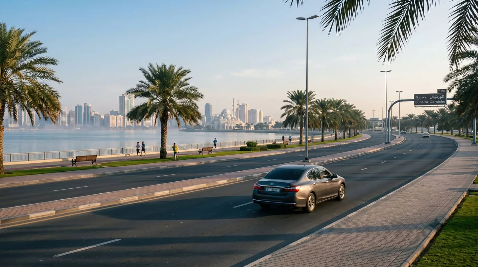 Buhaira Corniche in Sharjah in the early morning, with a sedan on the road beside the lagoon